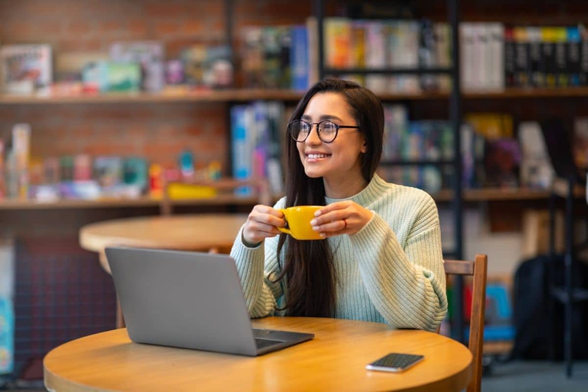 A person enjoying coffee with a bright, stain-free smile. A person drinking coffee with a bright white smile, showcasing tips to prevent teeth stains.