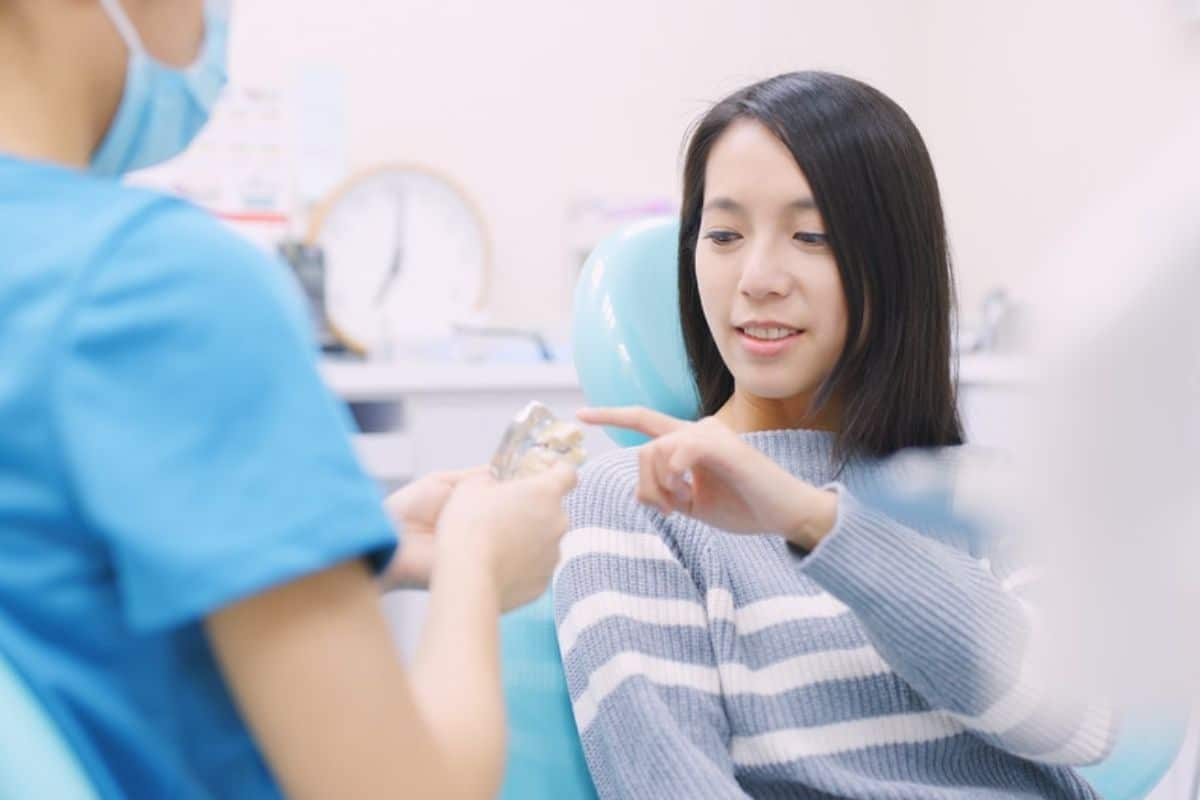 Dentist discussing dental implant options Dentist discussing dental implant options with a patient.