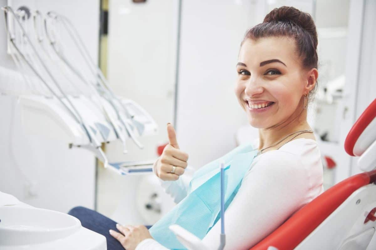 Smiling woman with perfect teeth after dental implants.