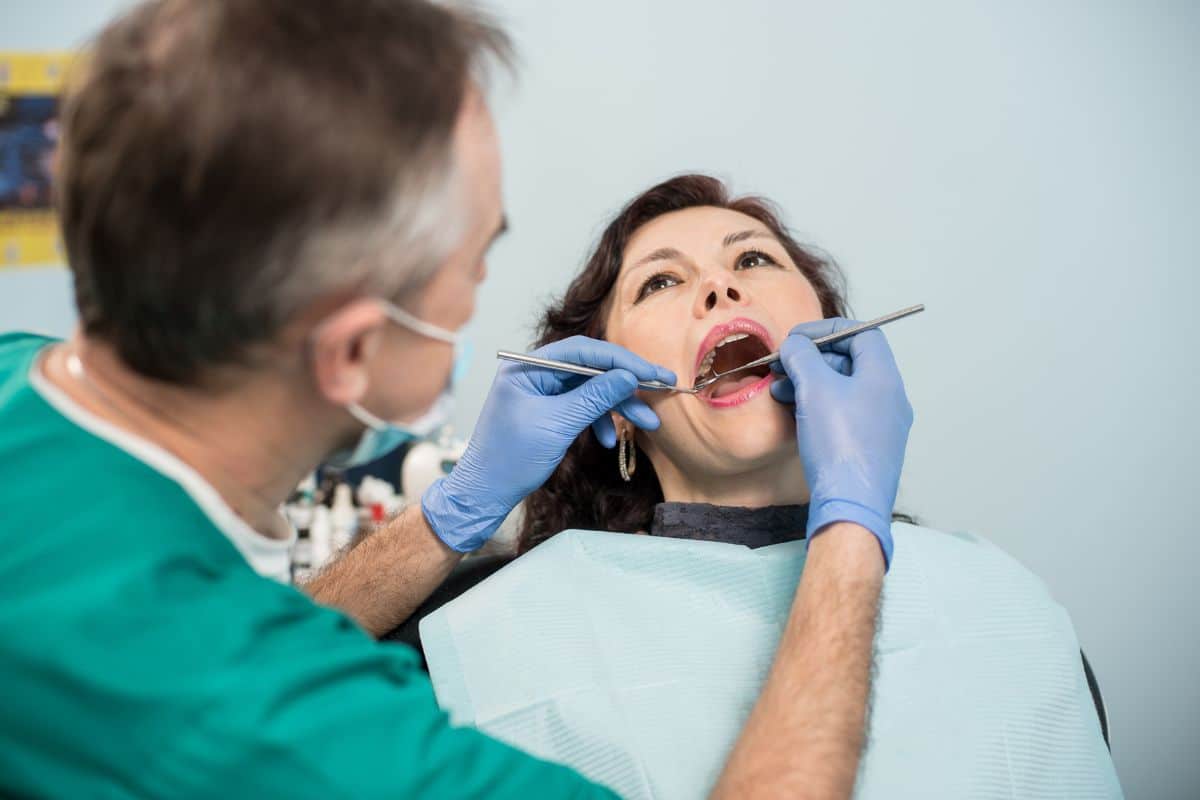 Dentist examining patient’s mouth for gum inflammation and oral health issues.