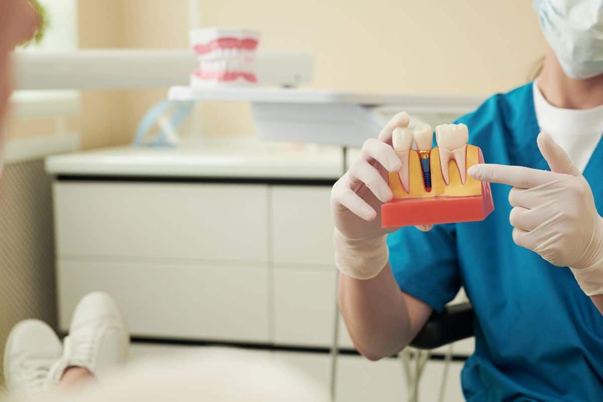 Dental Implants Dentist explaining dental implant care and post-surgery healing guidelines to a patient.